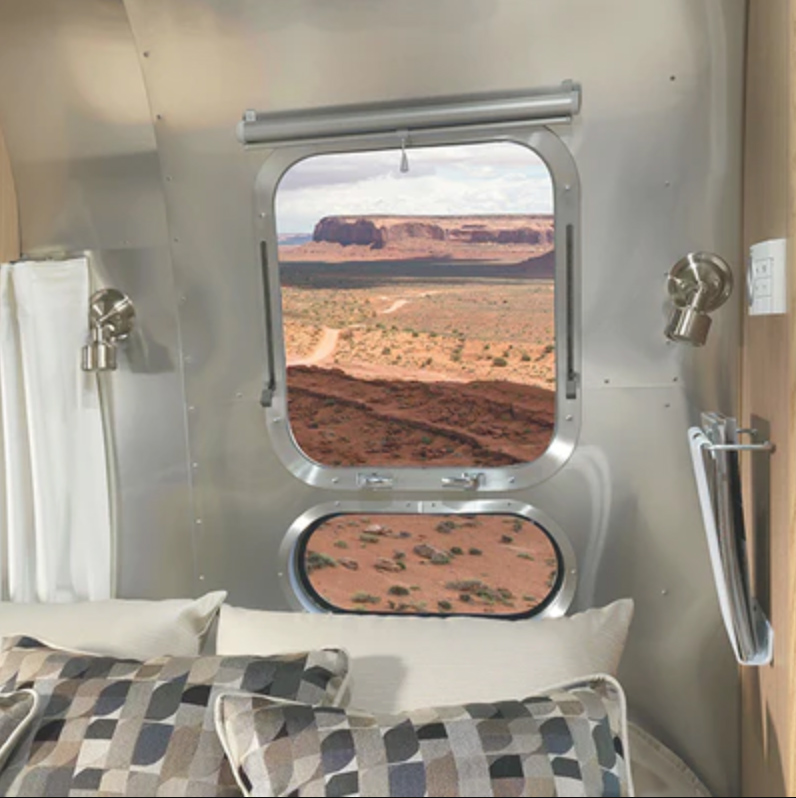 Interior of RV view from bed showing desert canyon outside a window